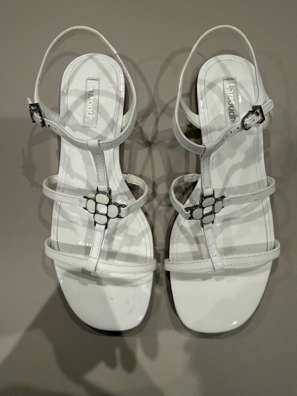 Larroude White Patent T-Strap Sandals with Floral Hardware